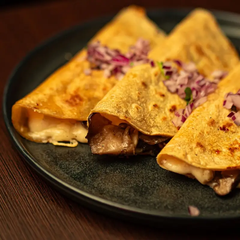 Quesadilla de setas en recado negro en Piñata Cantina, cocina mexicana en Barcelona